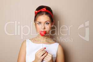 Beautiful young woman holding a red heart