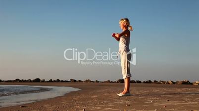 Young girl doing exercises on the beach