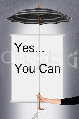 Hand holding umbrella over billboard