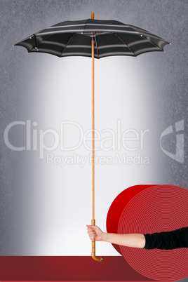 Hand holding umbrella on red carpet roll