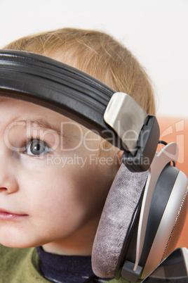 young child on couch with headphone