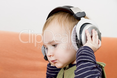 young child on couch with headphone