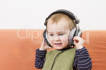 young child on couch with headphone