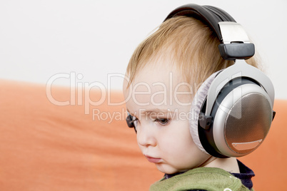 young child on couch with headphone