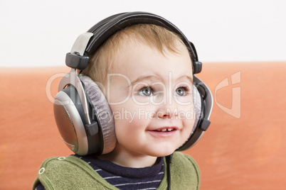 young child on couch with headphone