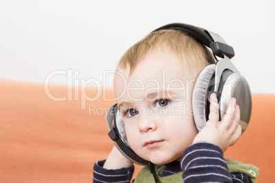 young child on couch with headphone