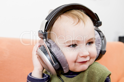 young child on couch with headphone