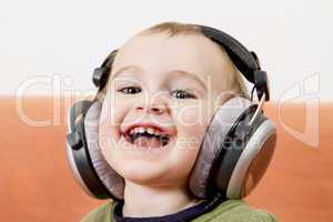 young child on couch with headphone