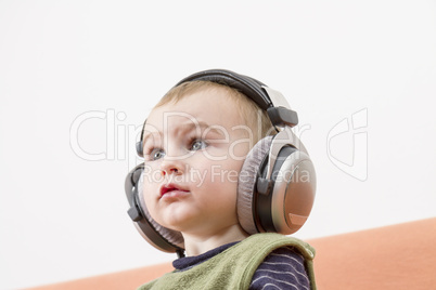 young child on couch with headphone