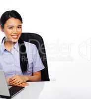 Smiling Asian businesswoman at her desk