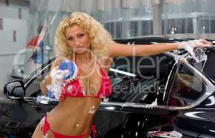 Beautiful blonde washing a car