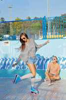 two beautiful young girls in sunglasses in an empty pool