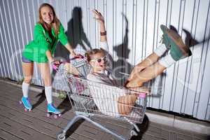 two beautiful young girls with a skateboard and roller skates