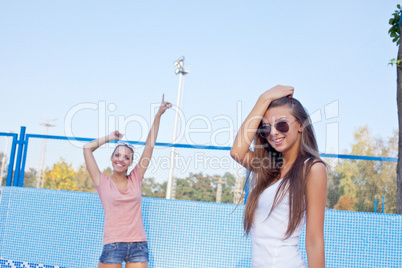 two beautiful young girls on the floor of an empty pool