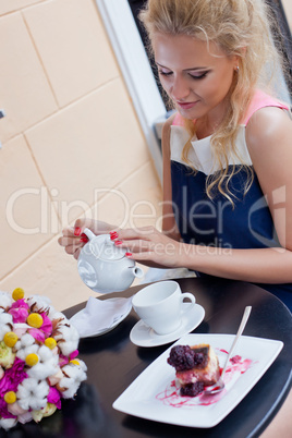 a beautiful young blond girl in summer dress at the table