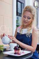 a beautiful young blond girl in summer dress at the table