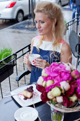 a beautiful young blond girl in summer dress at the table