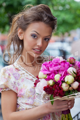 a beautiful young girl in summer dress with a bunch of flowers