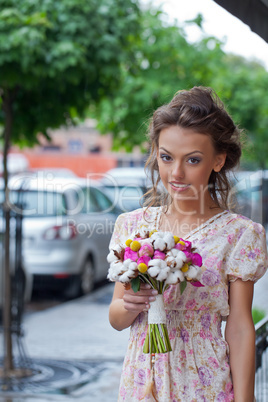 a beautiful young girl in summer dress with a bunch of flowers