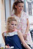 two beautiful young girls in summer outfit have lunch