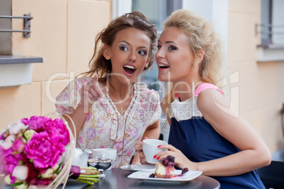 two beautiful young girls in summer outfit have lunch