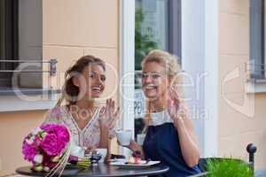 two beautiful young girls in summer outfit have lunch