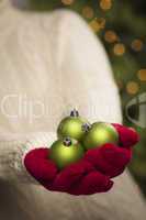Woman Wearing Seasonal Red Mittens Holding Green Christmas Ornam