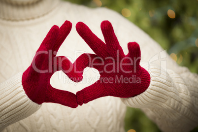 Woman Wearing Red Mittens Holding Out a Heart Hand Sign