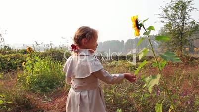 Cute child with sunflower in autumn field