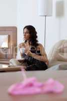 Brunette woman drinking coffee in hotel room