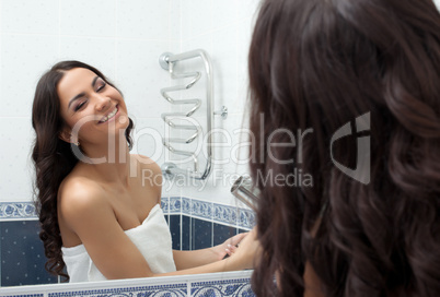 Pretty woman with hairdryer in bathroom
