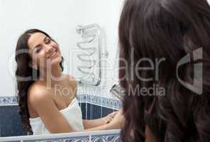 Pretty woman with hairdryer in bathroom
