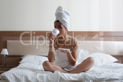 Young woman drinking coffee in bed