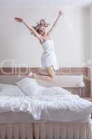 pretty blond woman in towels jump on big bed