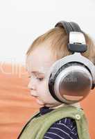 young child on couch with headphone