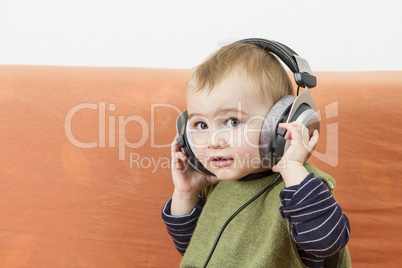 young child on couch with headphone