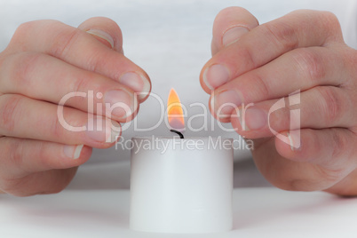 Women hands protect candlelight