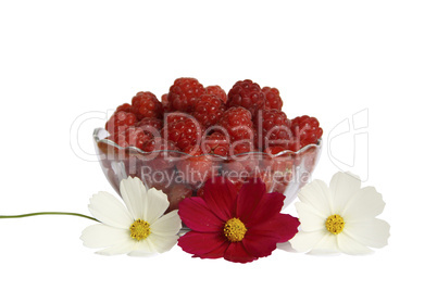 Berries raspberries in a glass vase on a table with flowers