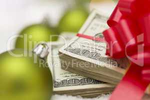 Stack of Hundred Dollar Bills with Bow Near Christmas Ornaments