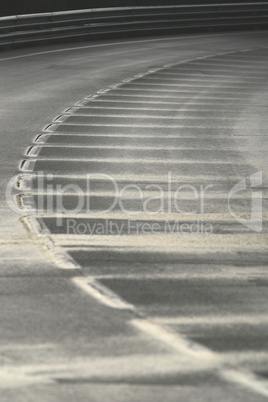 Wet bend in a road with a broken white line