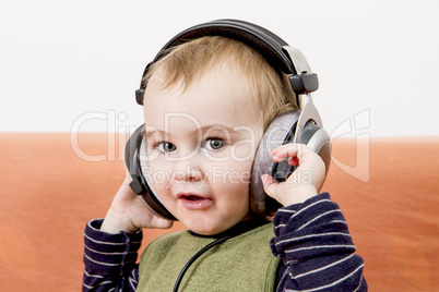 young child on couch with headphone