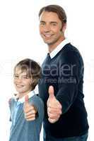 Confident father and son duo gesturing thumbs up