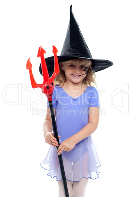 Cute girl holding pitchfork and wearing witches hat