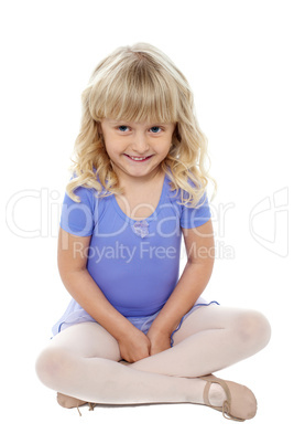 Adorable kid sitting with crossed legs on the floor