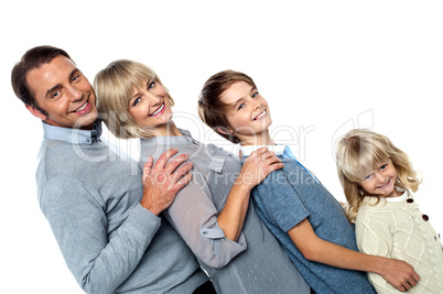 Cheerful family of four leaning backwards