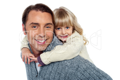 Cute little daughter piggybacking her father