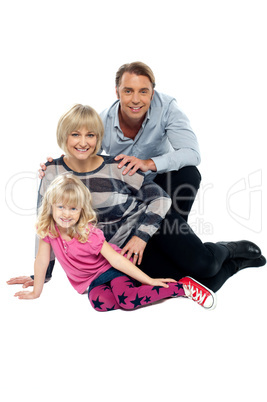 Young family of three posing indoors. Studio shot