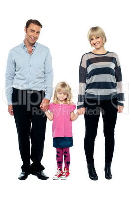 Cute daughter holding hands of her parents tightly