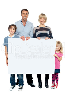 Active young family displaying blank ad board