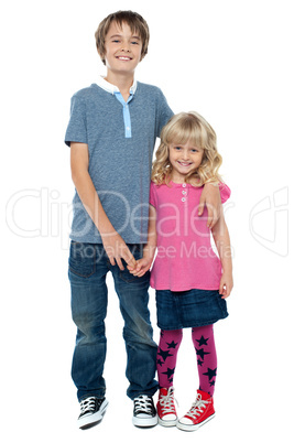 Smart boy holding cute sisters hand and embracing her